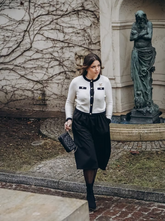 a lady in a contrast trim cardigan and black vest dress